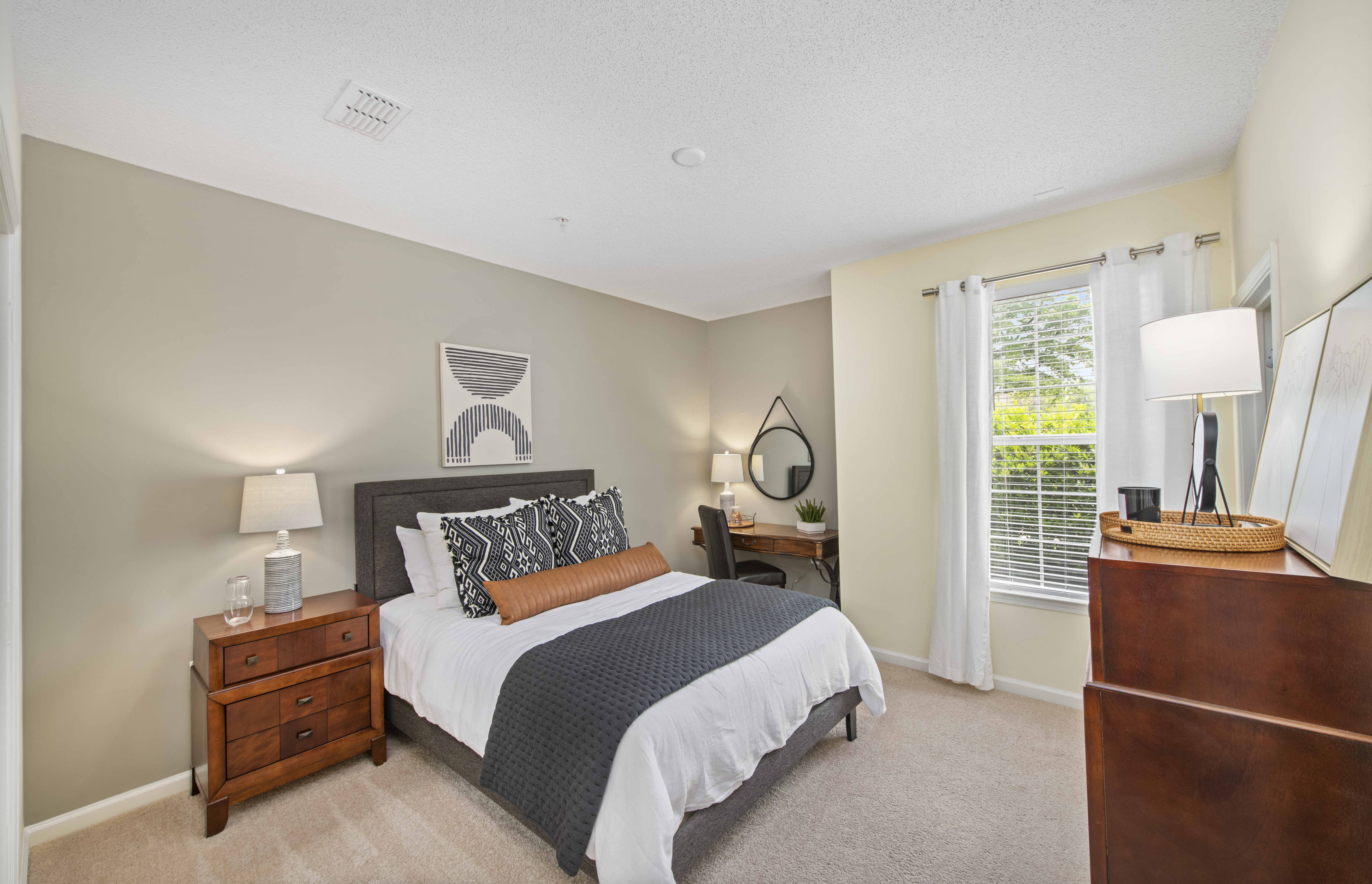 a bedroom with a bed and a dresser and a window
