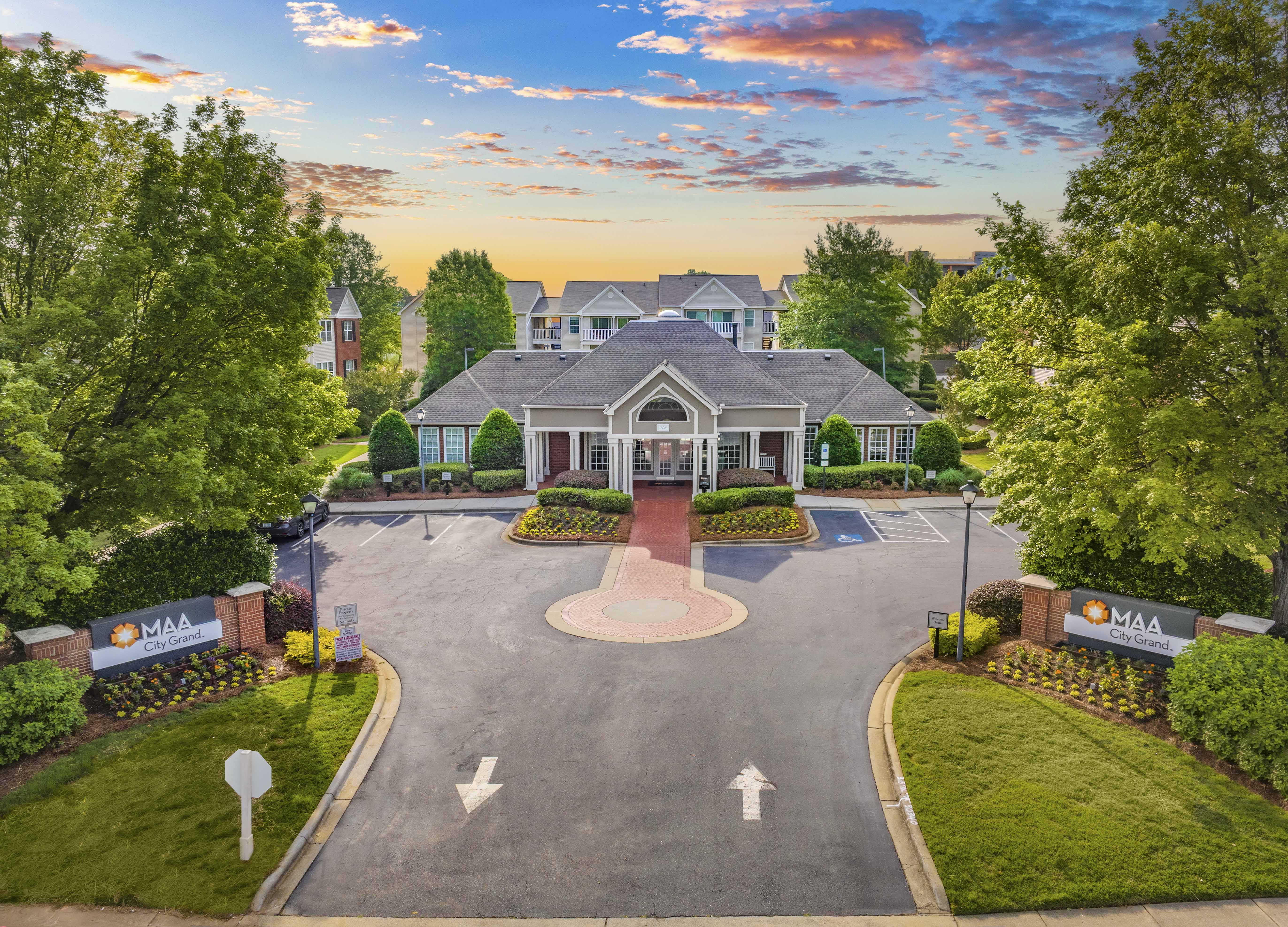 an aerial view of a house with a large driveway and a mansion