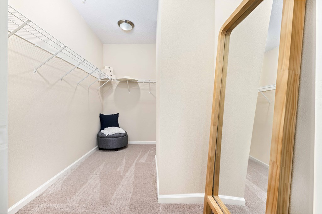 A hallway with a chair and a mirror.