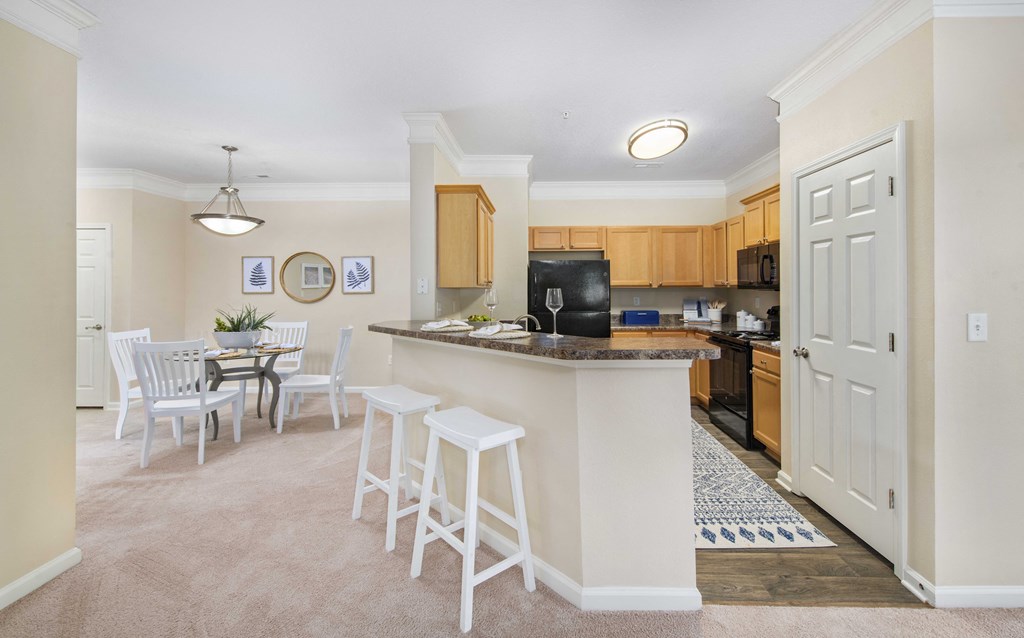 A kitchen with a bar area and a dining table.