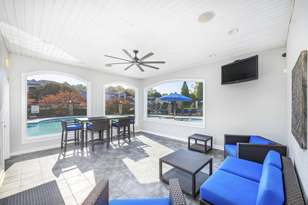 A patio with a table and chairs overlooking a pool.