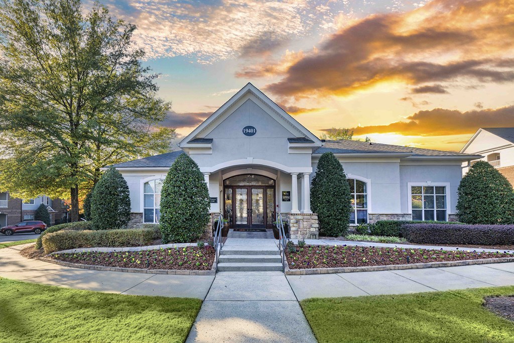 A white building with a dark roof and a sign on it.
