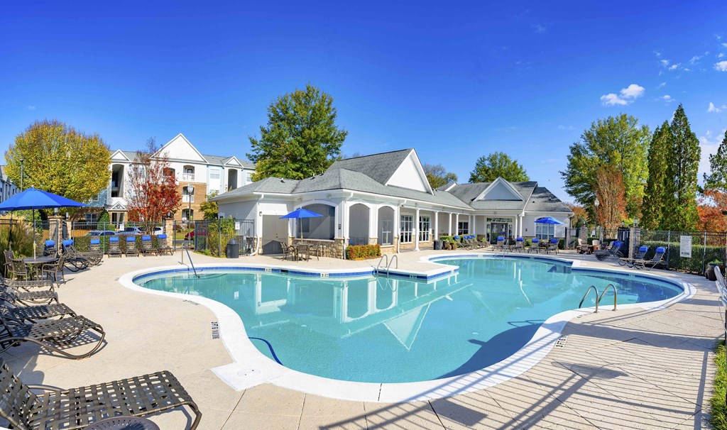 A large swimming pool with a building in the background.