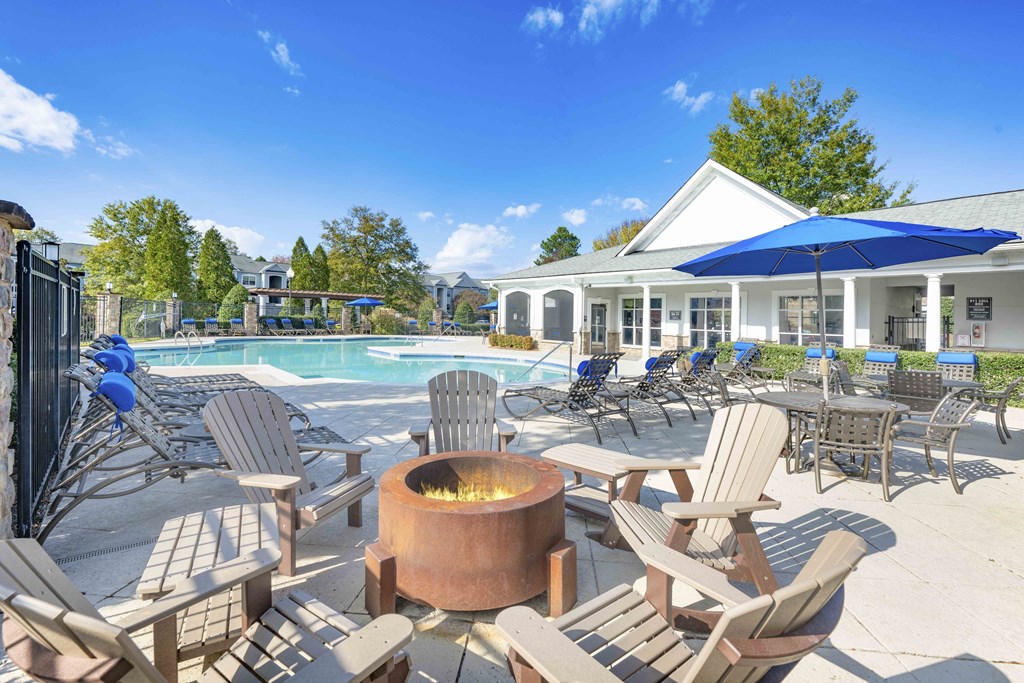 A poolside area with chairs and a fire pit.
