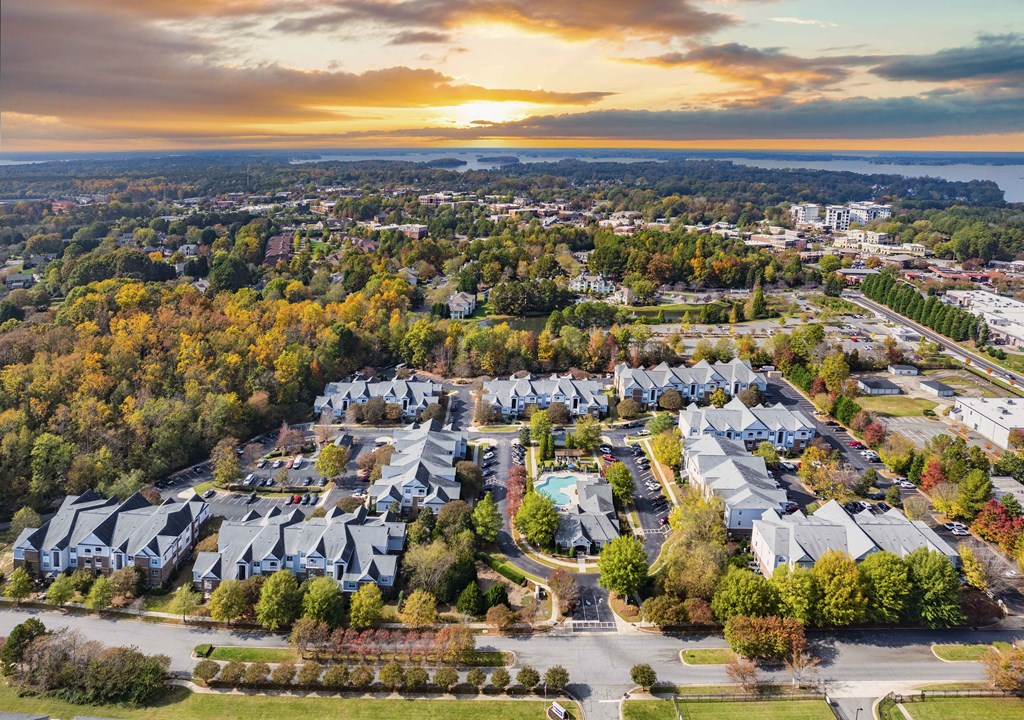 A sunset view of a residential area with houses and trees.
