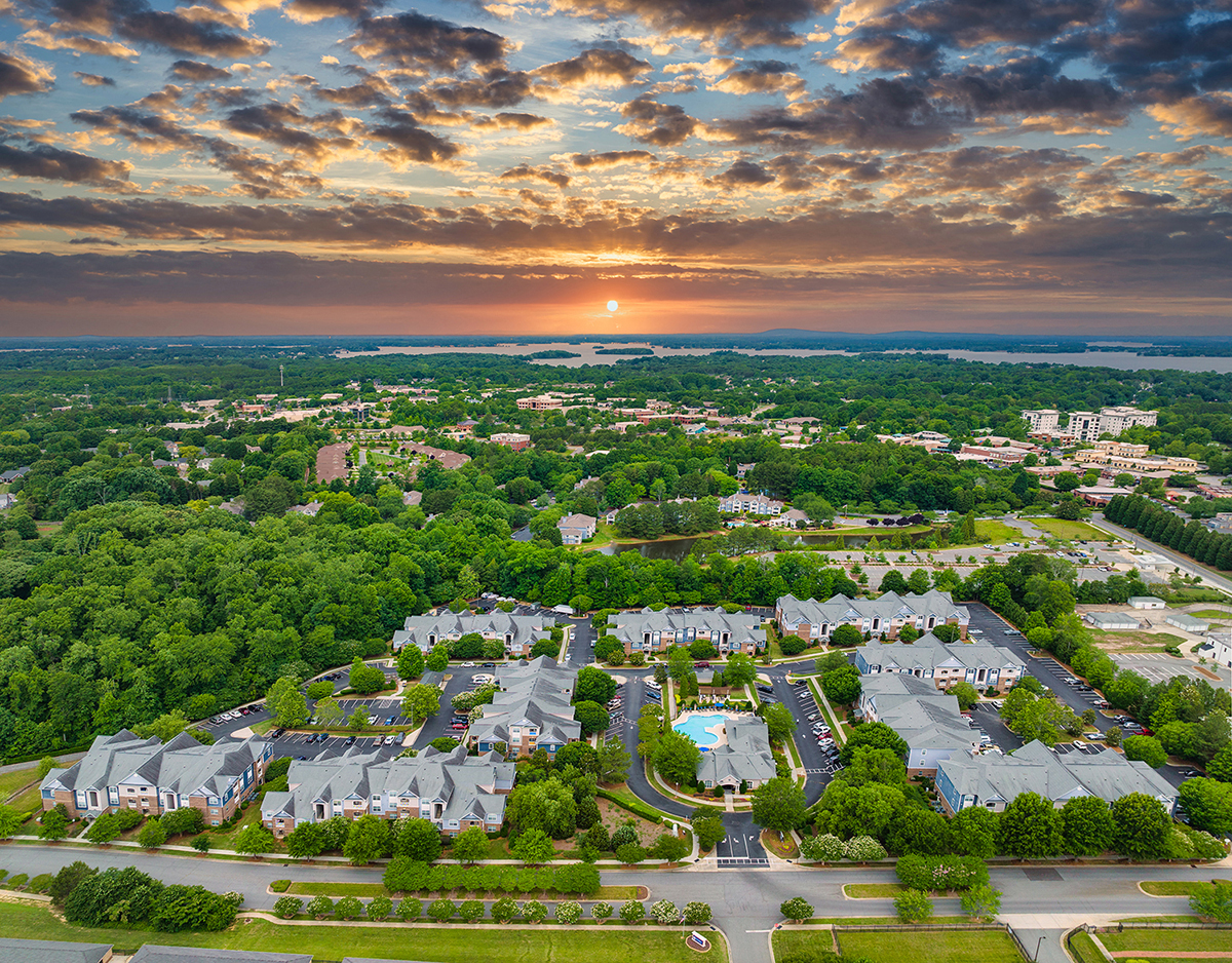 an aerial view of a neighborhood with houses and trees at sunset