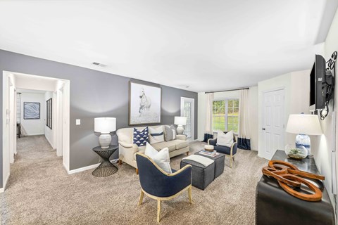 A living room with a blue chair and a black couch.