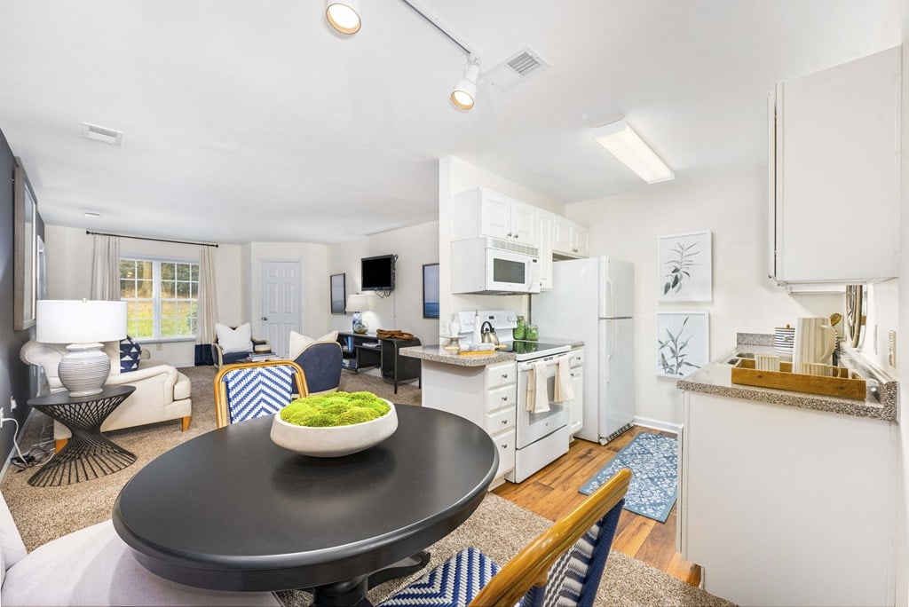 A black table with a bowl of green vegetables on it.