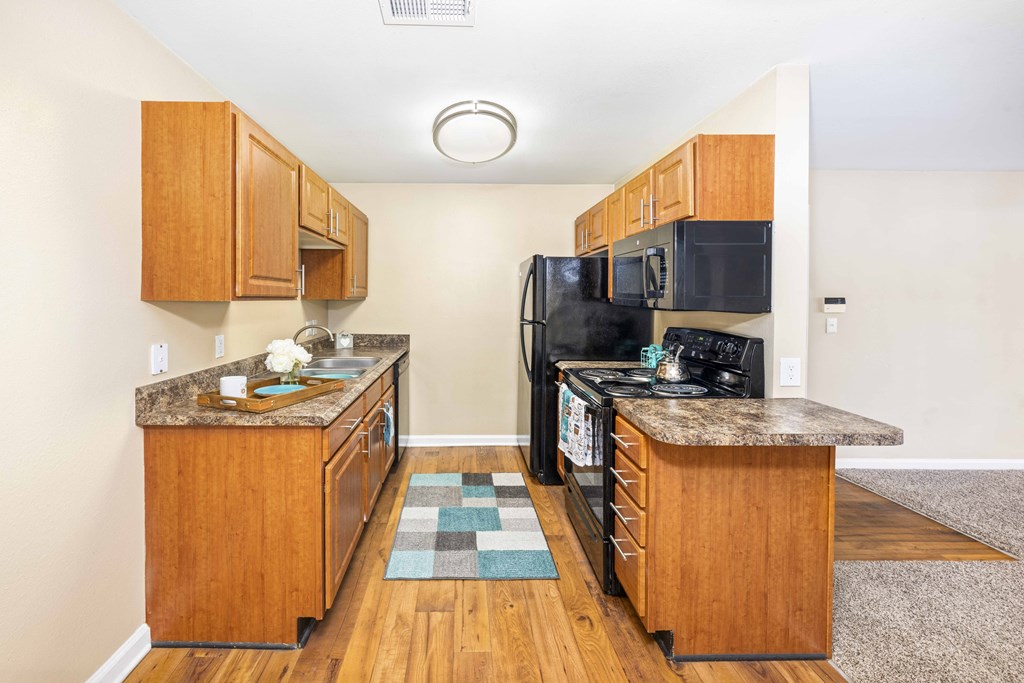 A kitchen with wooden cabinets and black appliances.