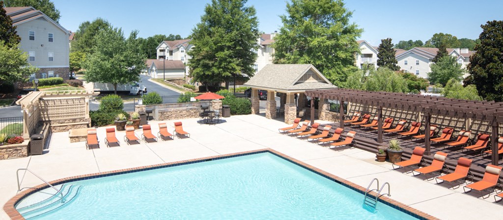 a swimming pool with lounge chairs at the resort on a sunny day
