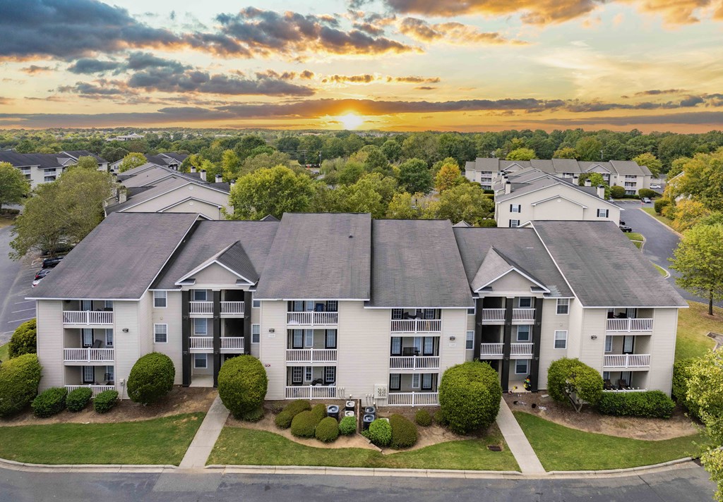an aerial view of an apartment building with a sunset behind it
