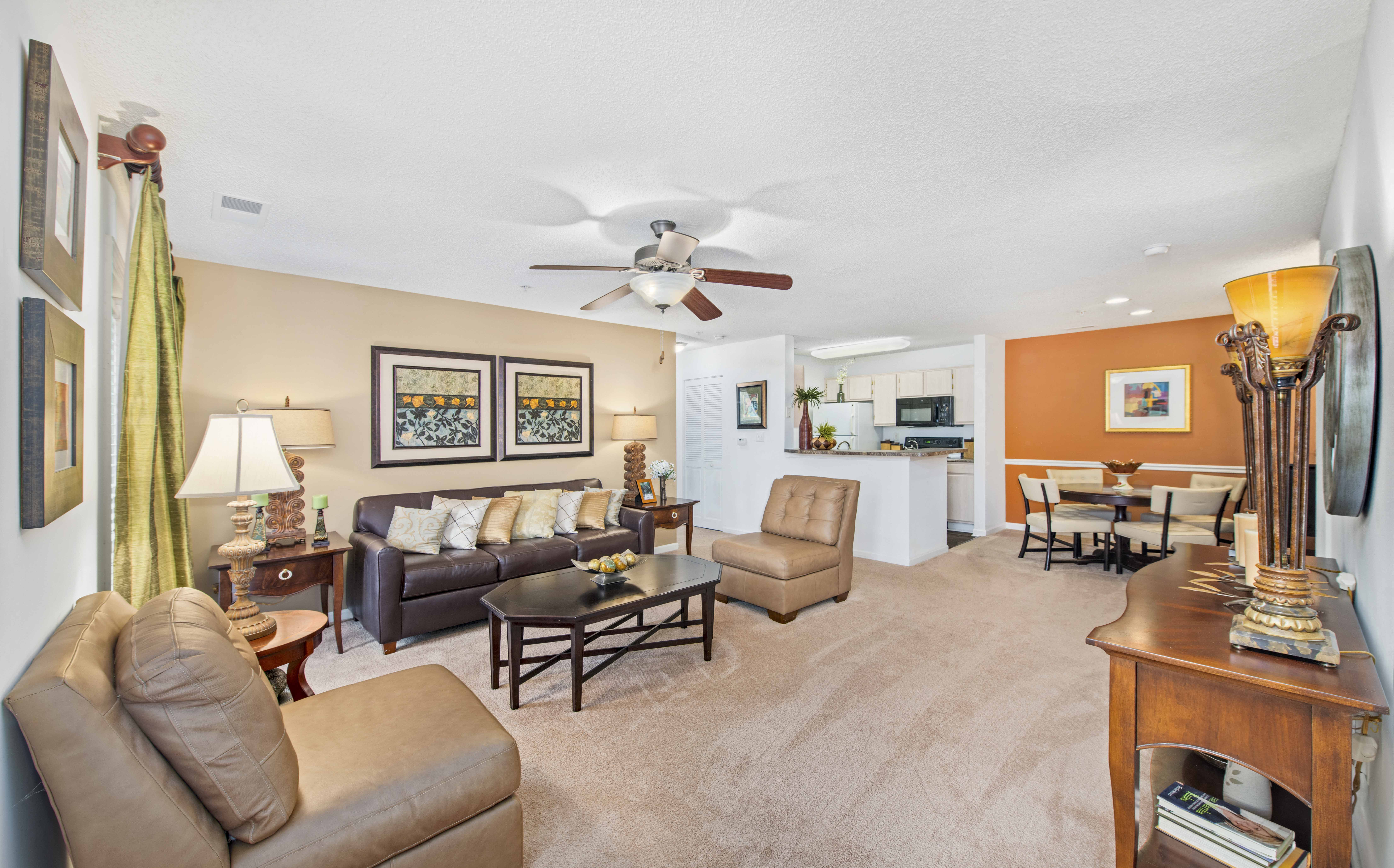 a living room with furniture and a ceiling fan