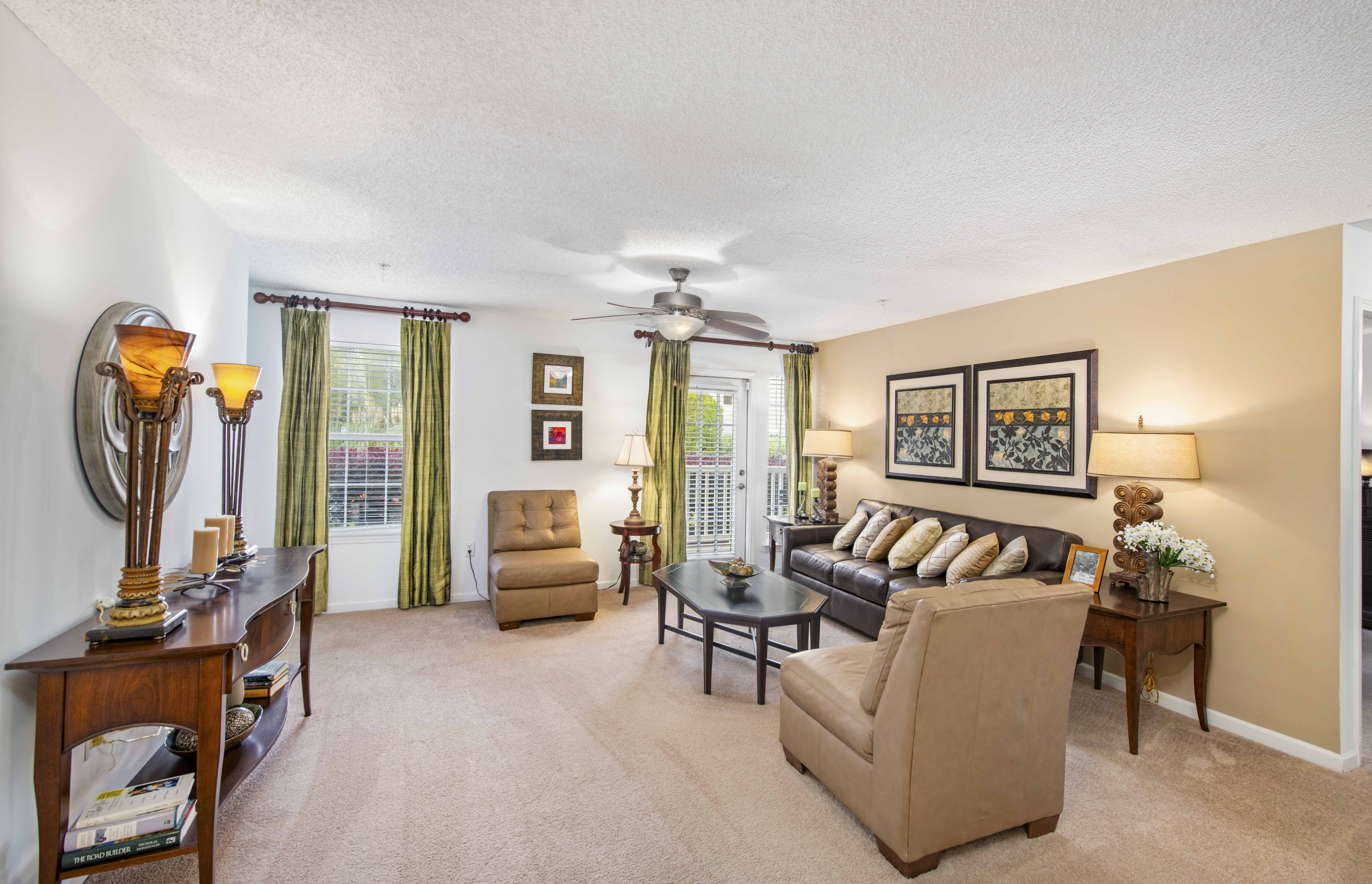 a living room filled with furniture and a ceiling fan
