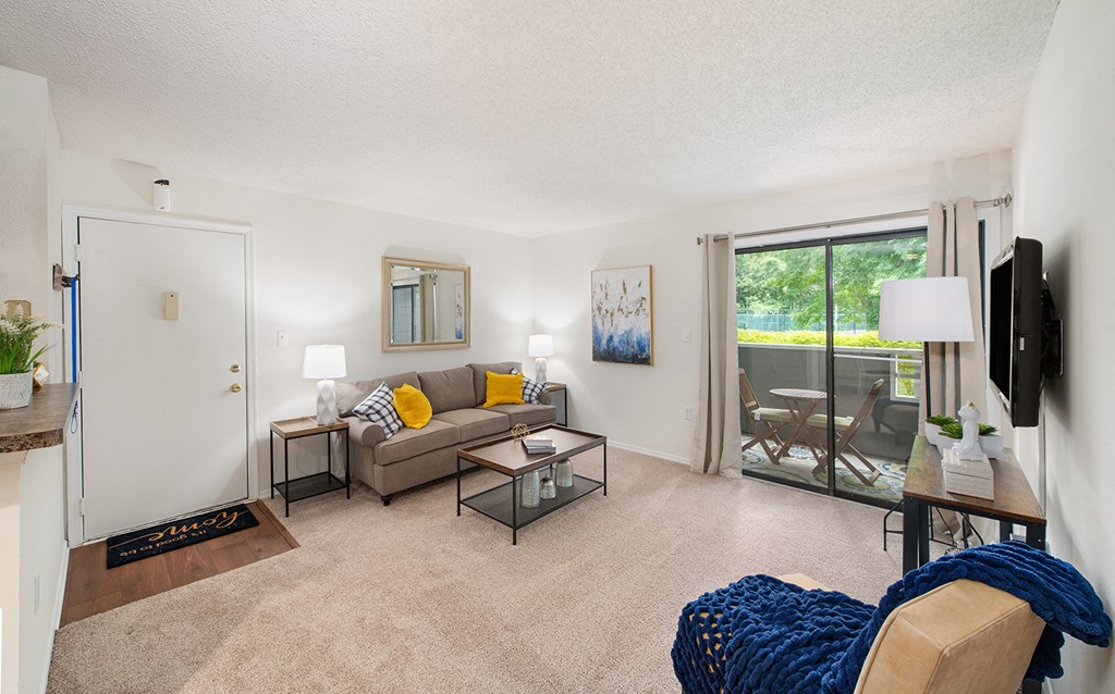 a living room with a couch and a chair and a sliding glass door