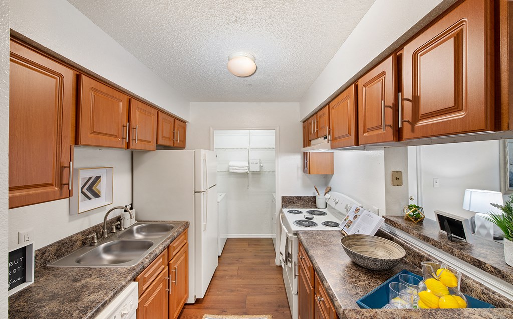 a kitchen with white appliances and wooden cabinets