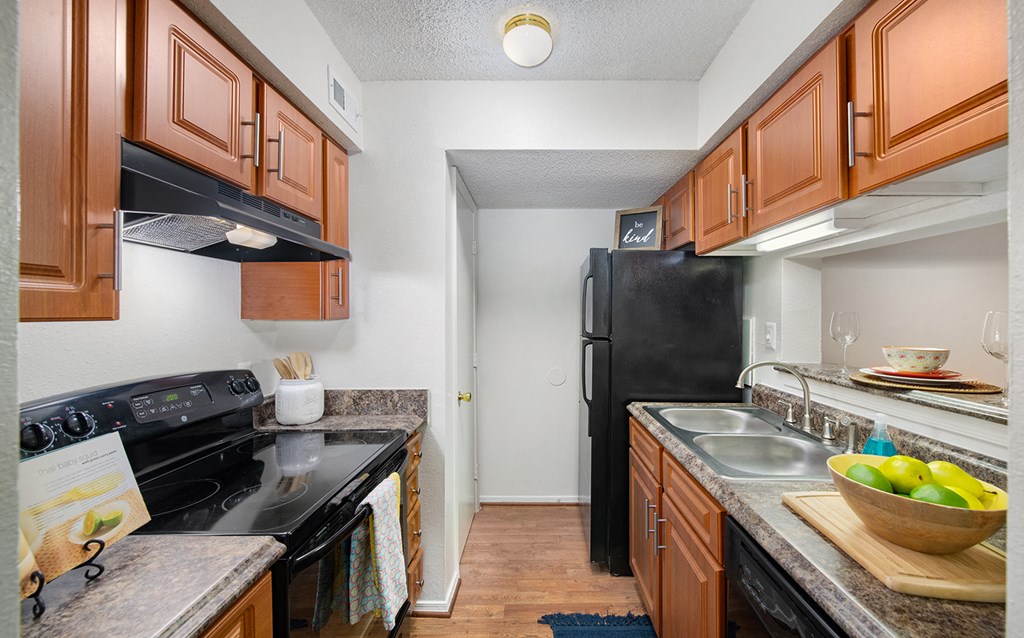 a kitchen with black appliances and wooden cabinets