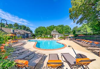 our resort style pool is filled with lounge chairs and umbrellas