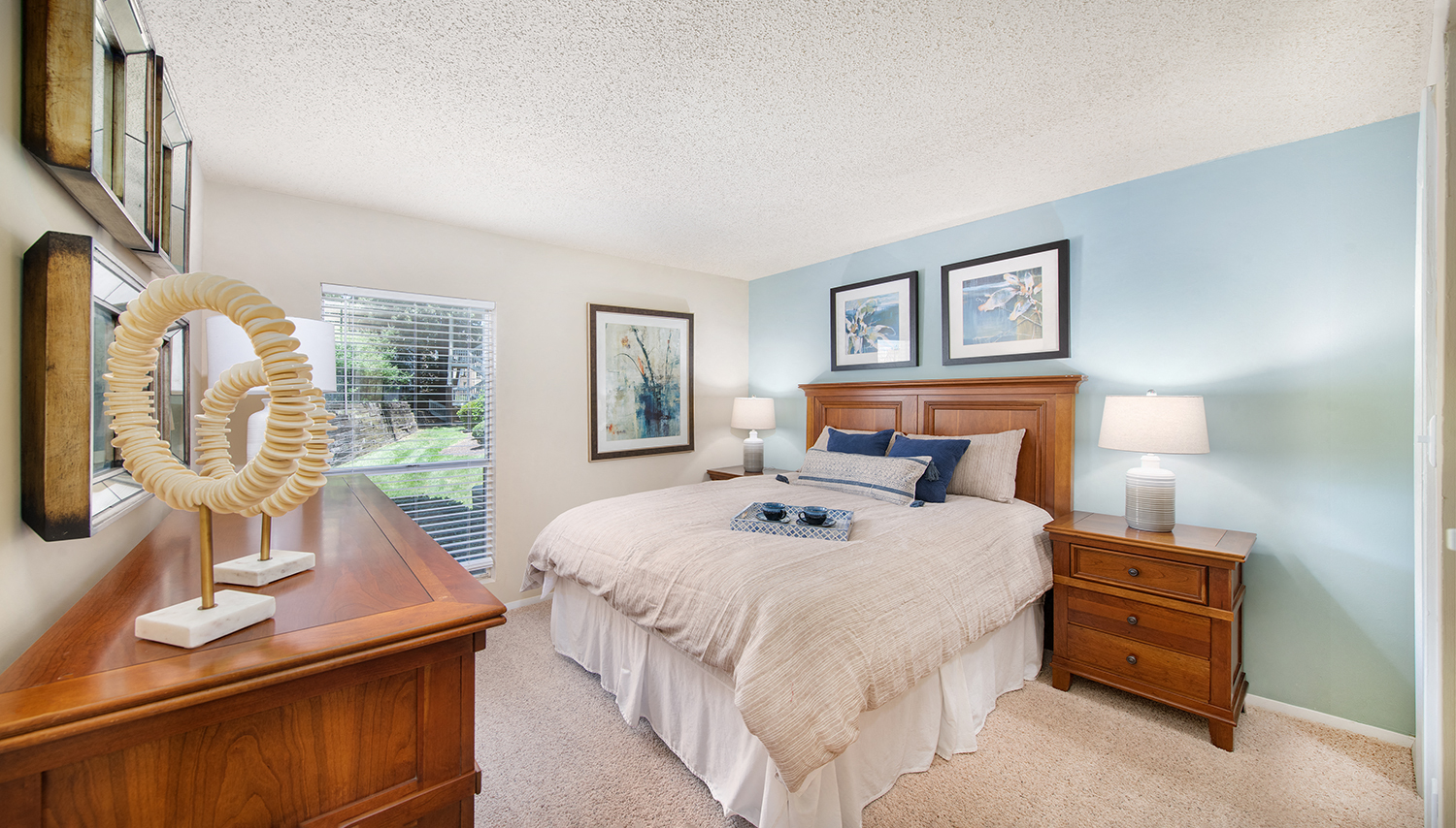 a bedroom with a bed and a dresser and a window