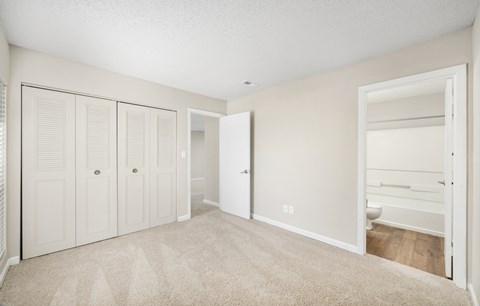 A bedroom with a carpeted floor and white walls.