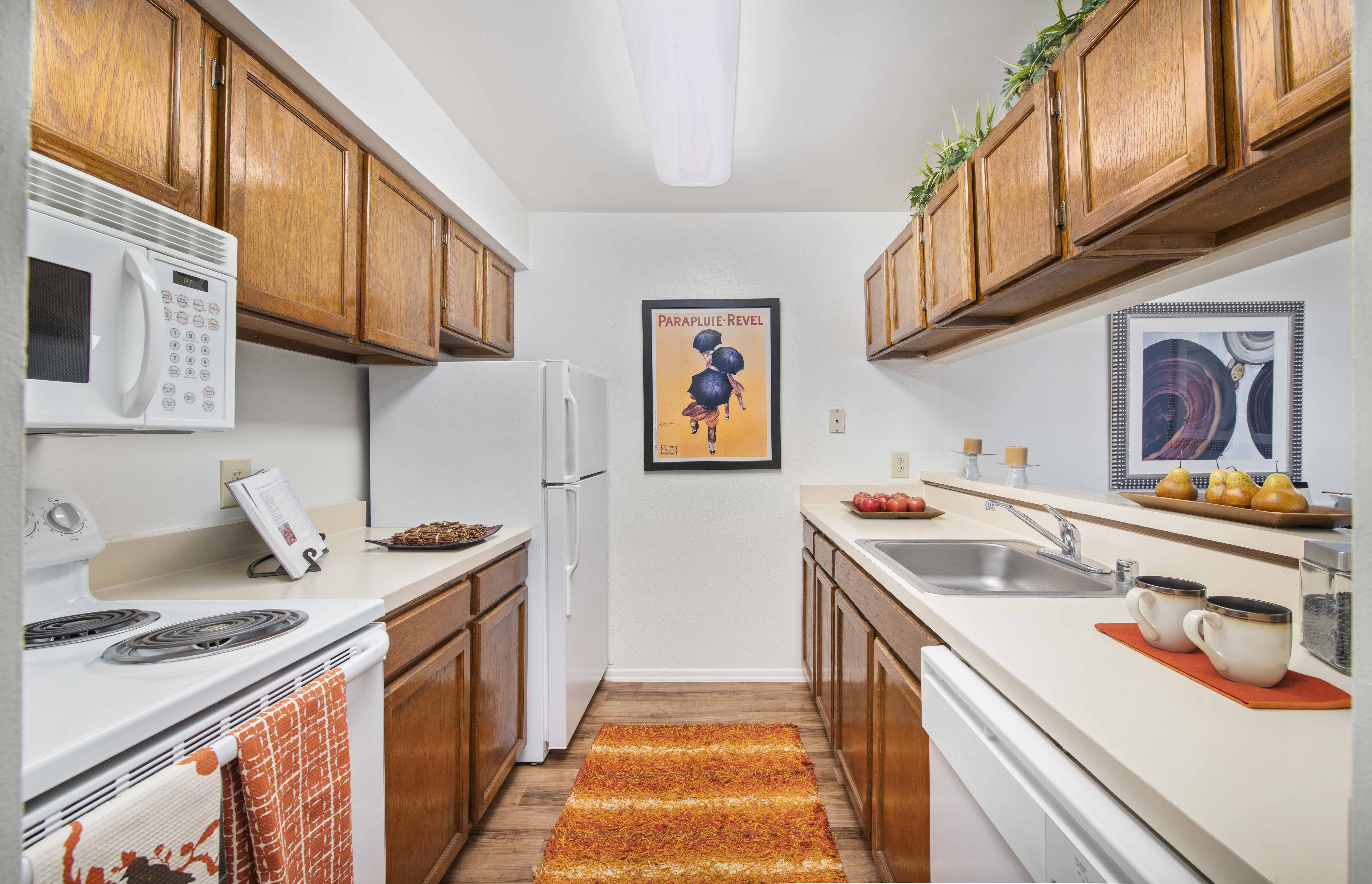 a kitchen with white appliances and wooden cabinets