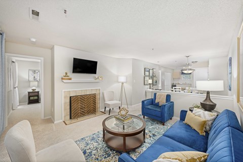 A living room with a blue couch and a fireplace.