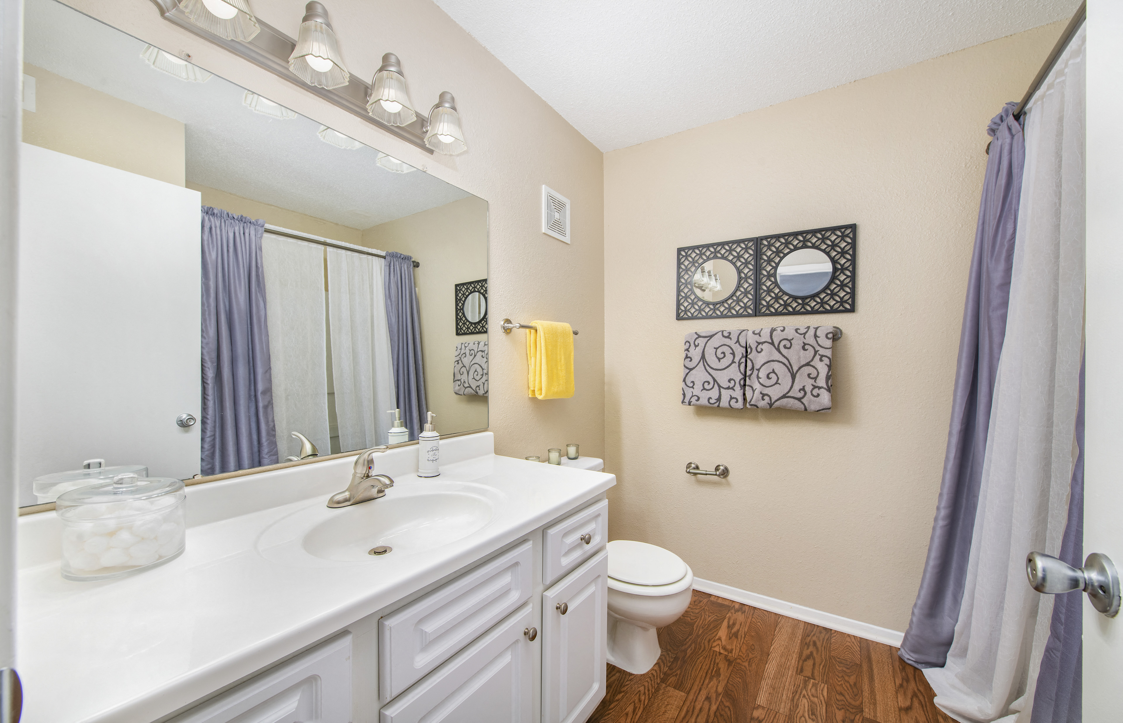 a bathroom with a large mirror and a sink and a toilet