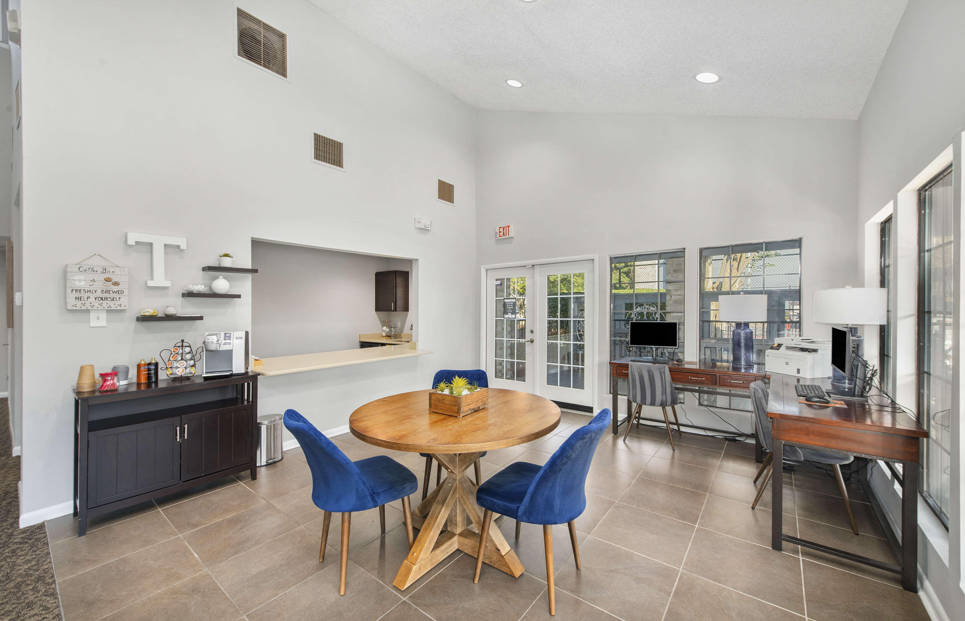 a dining room with a table and chairs and a kitchen with a counter and a