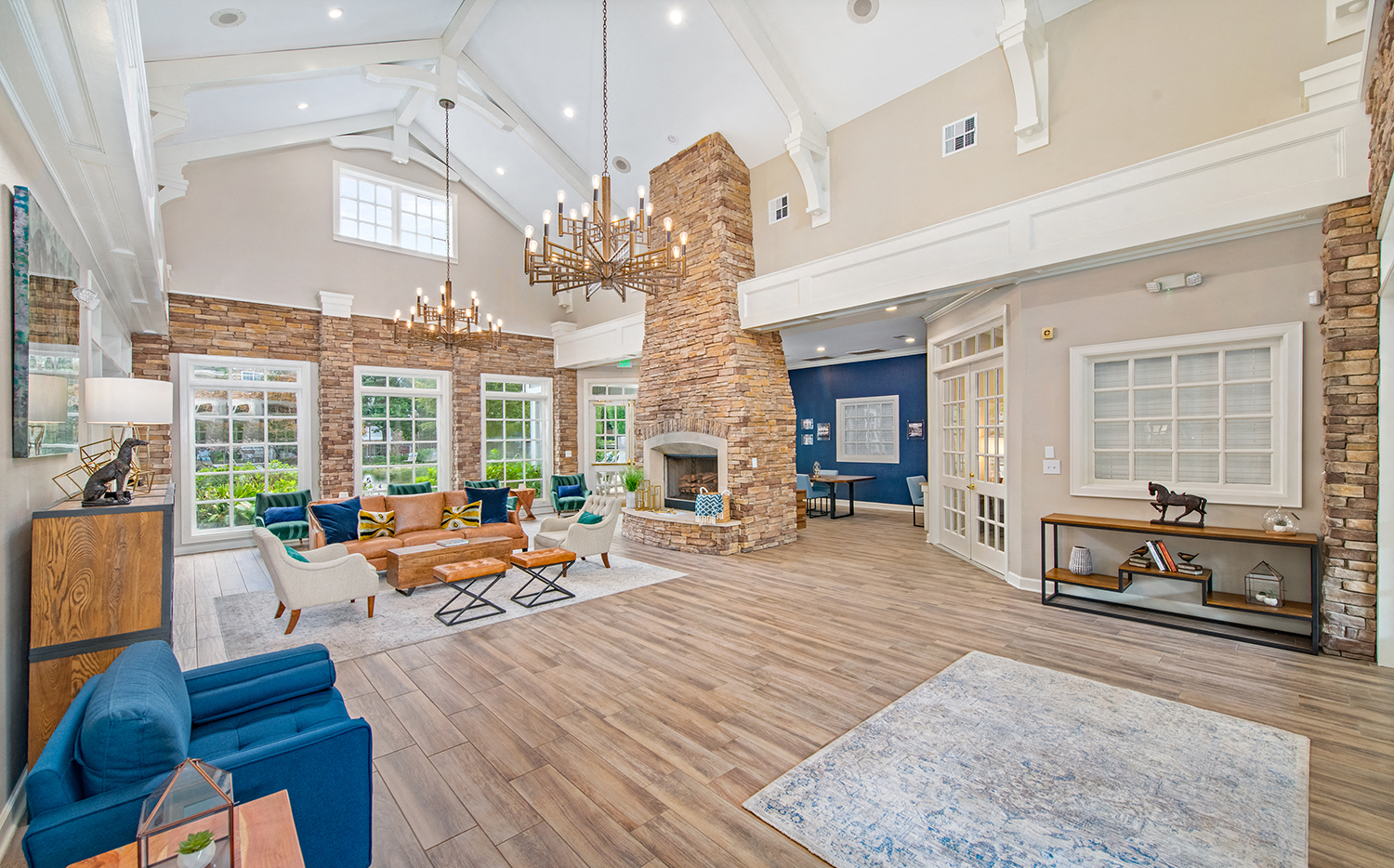 the living room has a large fireplace and a lot of windows