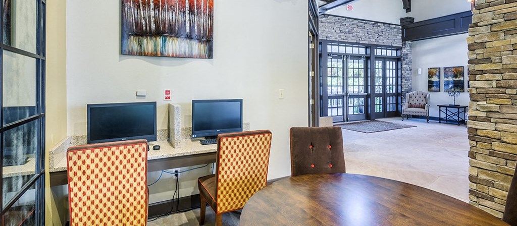 a dining room with a table and chairs and two televisions