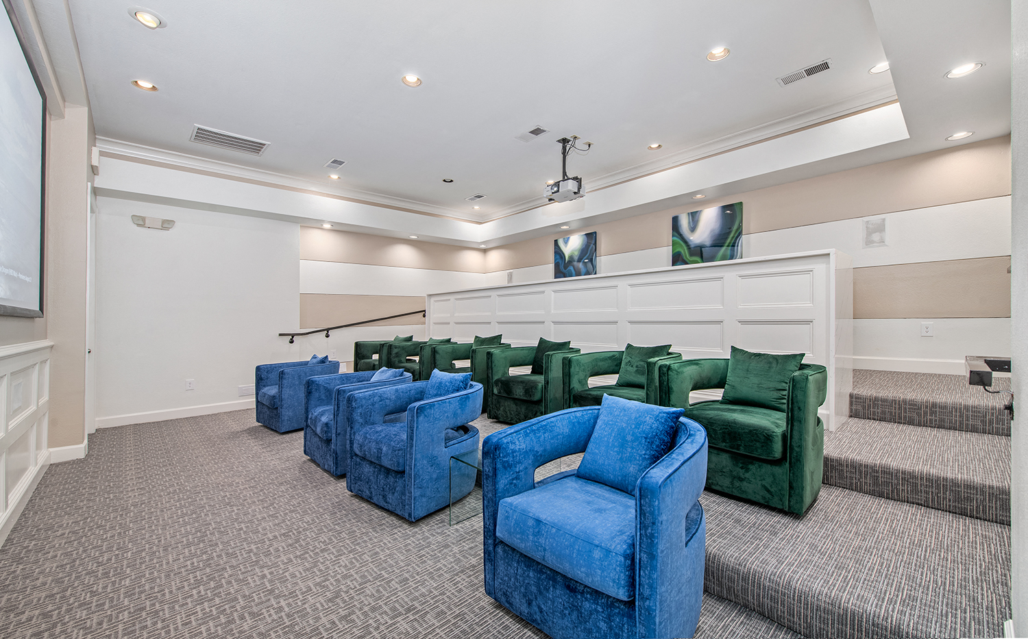 a large meeting room with blue chairs and green chairs