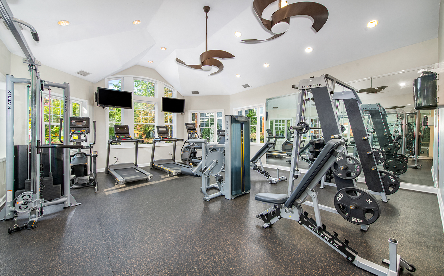 a gym with cardio equipment and weights on the floor