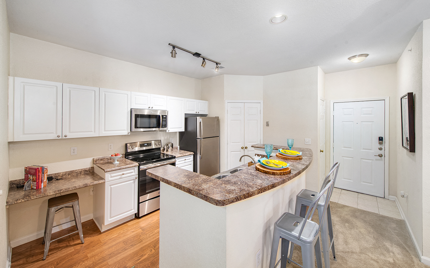 a kitchen with an island and a counter with bar stools