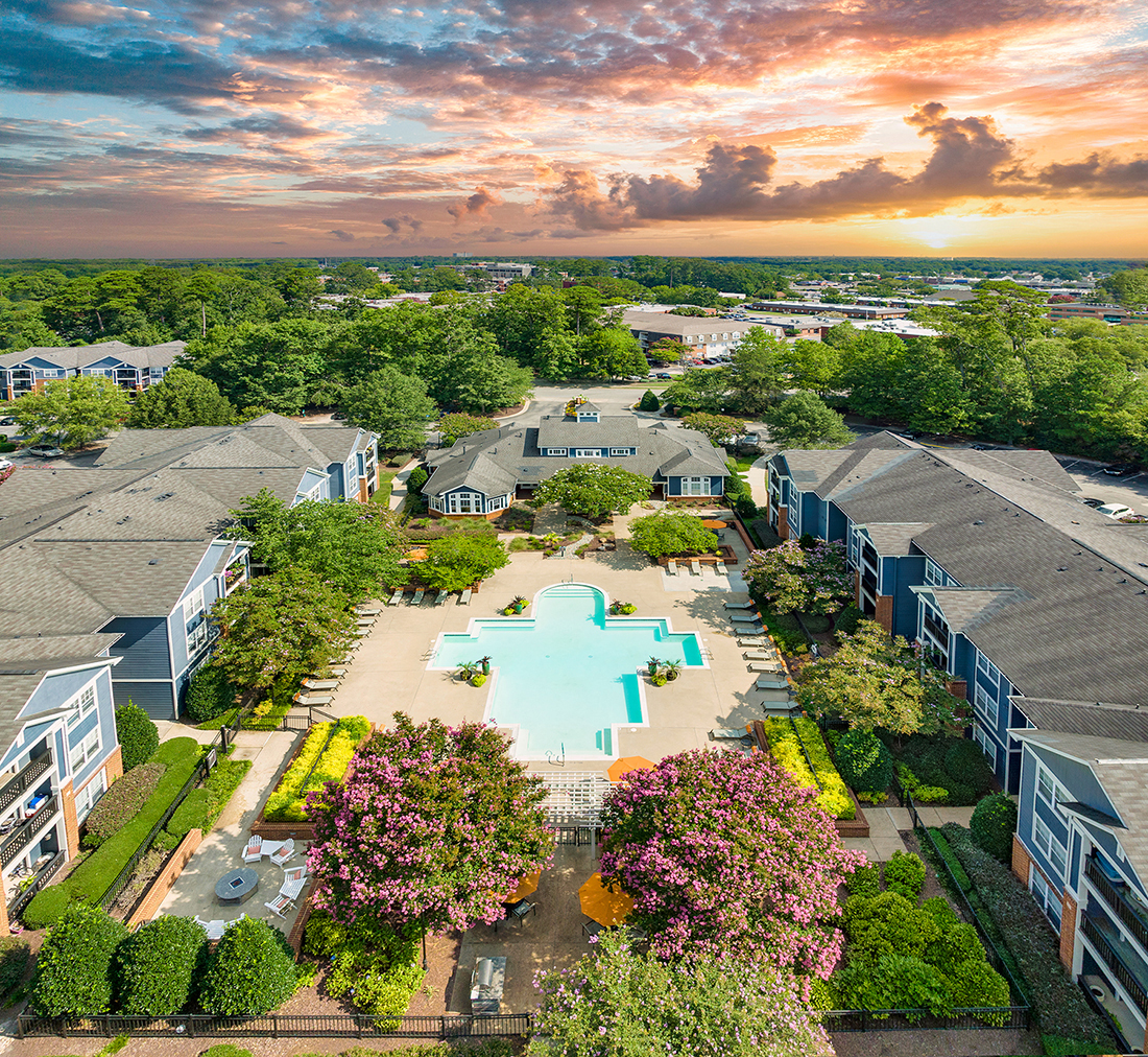 an aerial view of a swimming pool in a neighborhood with houses and trees