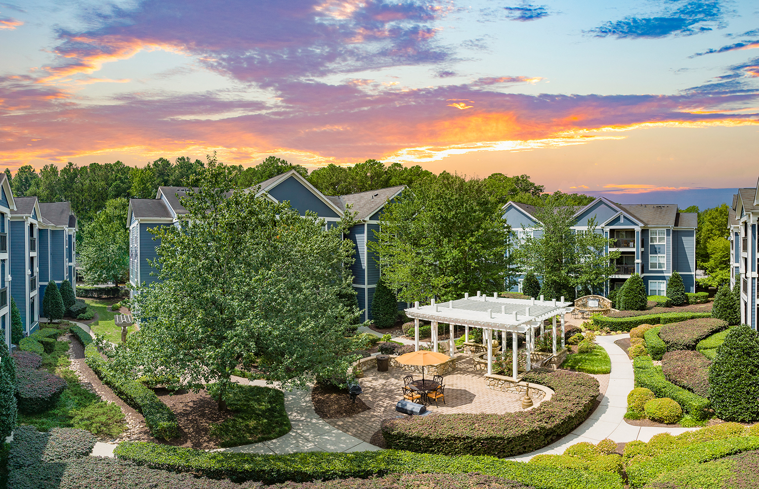 an aerial view of a building with trees and a patio and a courtyard