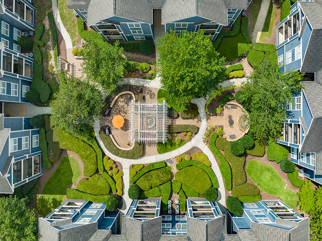 an aerial view of a park with trees and buildings