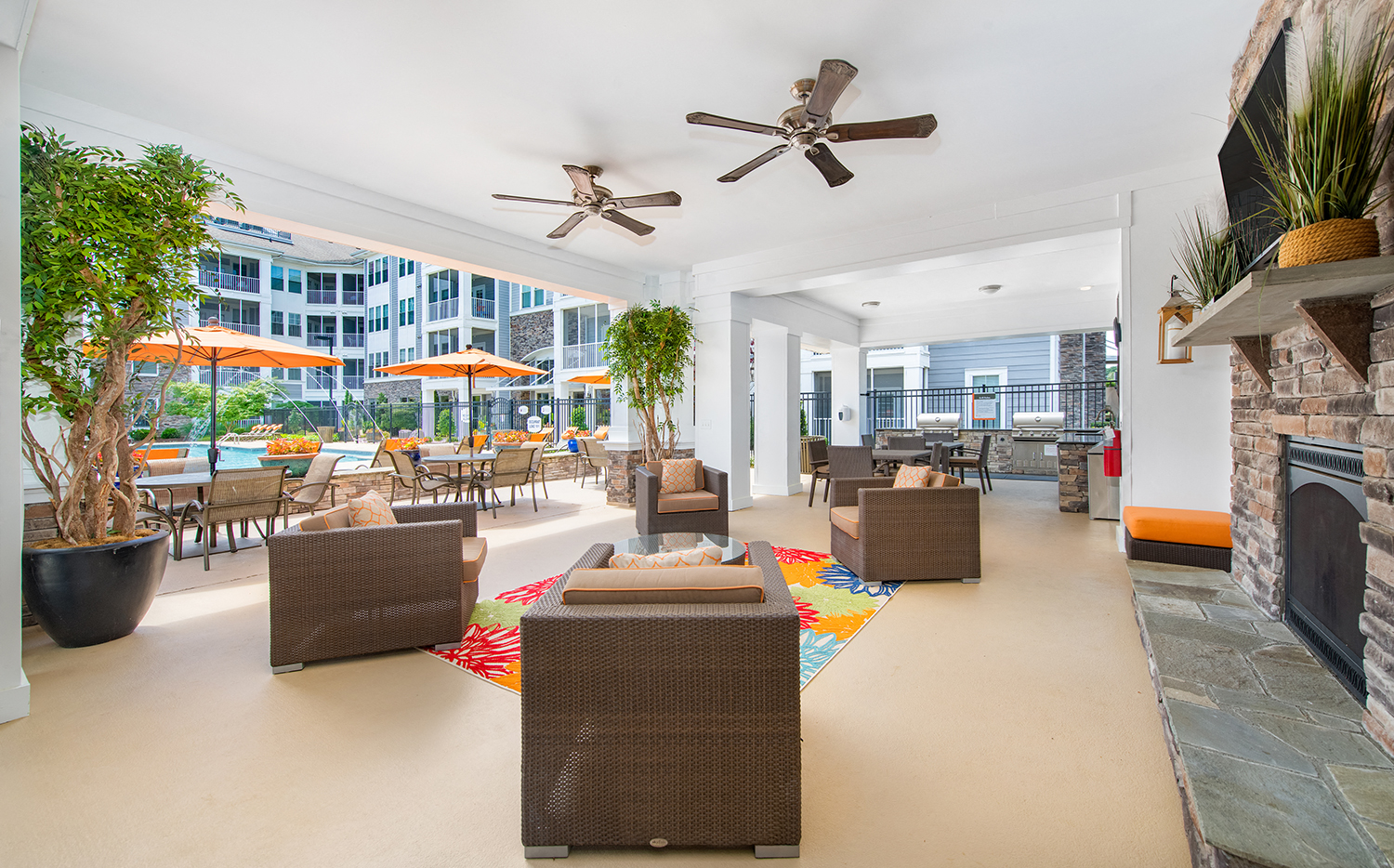 the living room has a fireplace and tables with chairs and umbrellas