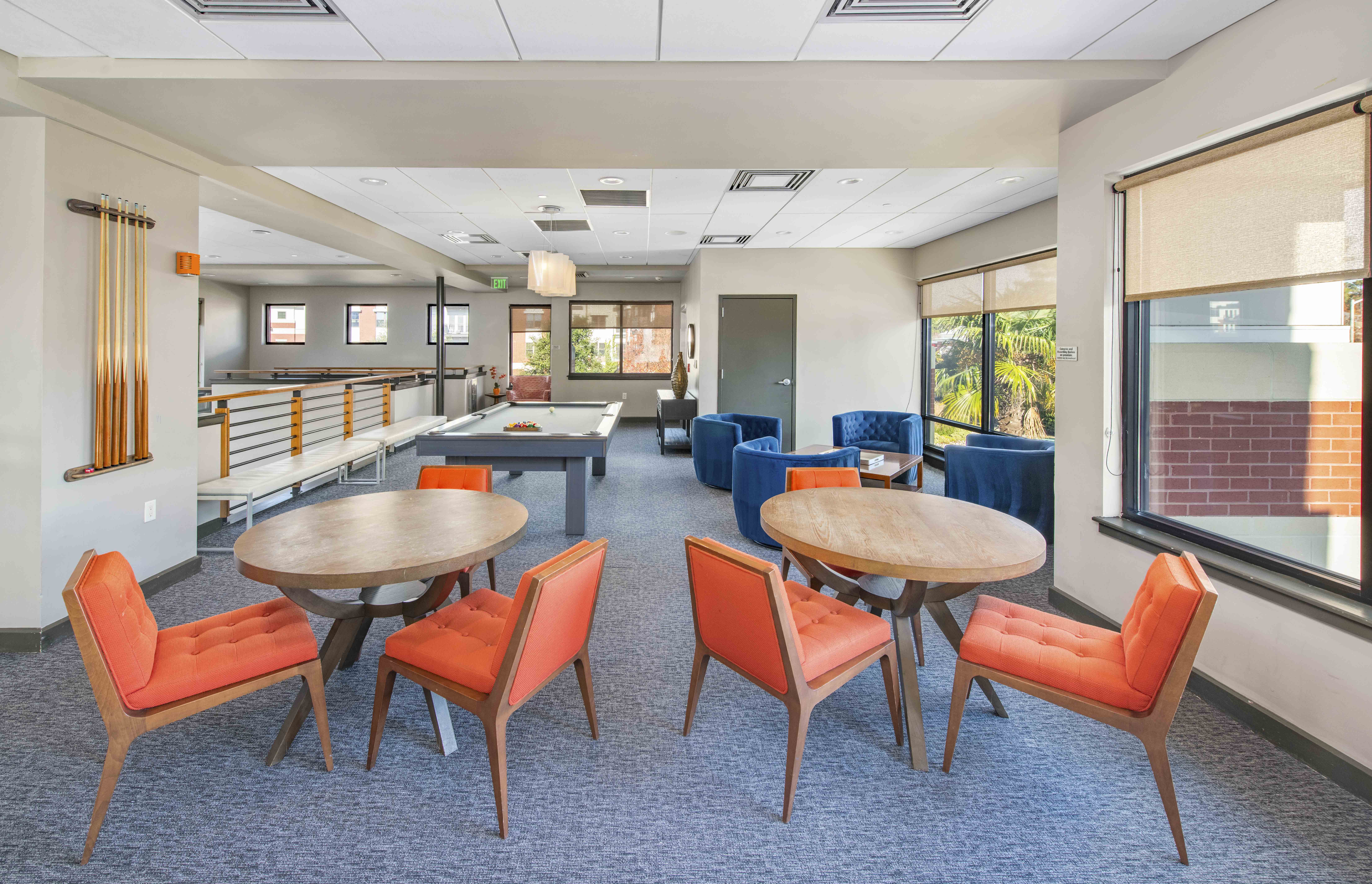 a lounge area with tables and chairs in a hall