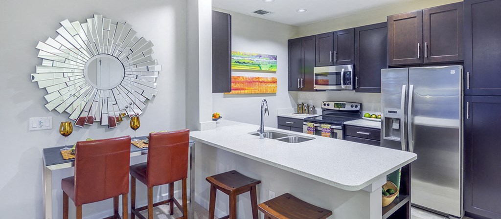 a kitchen with a white counter top and a stainless steel refrigerator