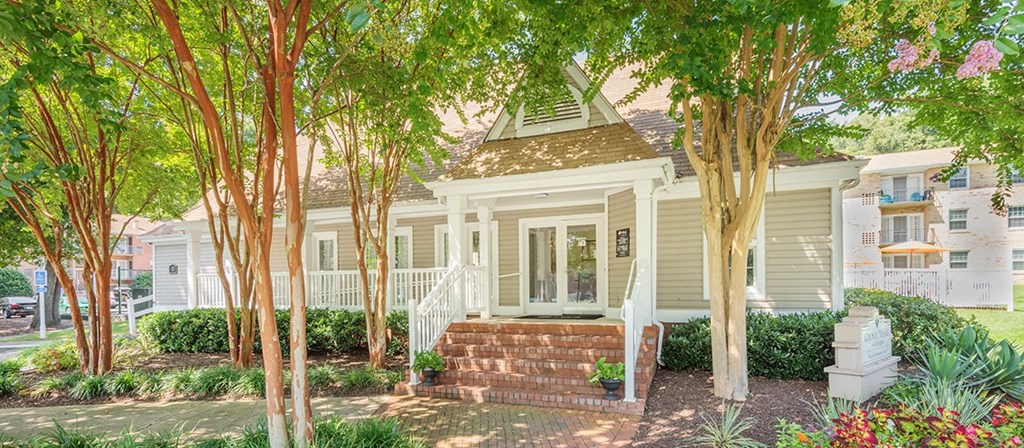 a small white house with trees in front of it