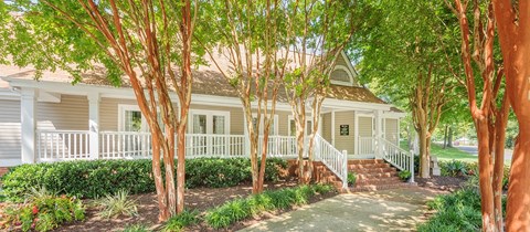 a small white house with trees in front of it