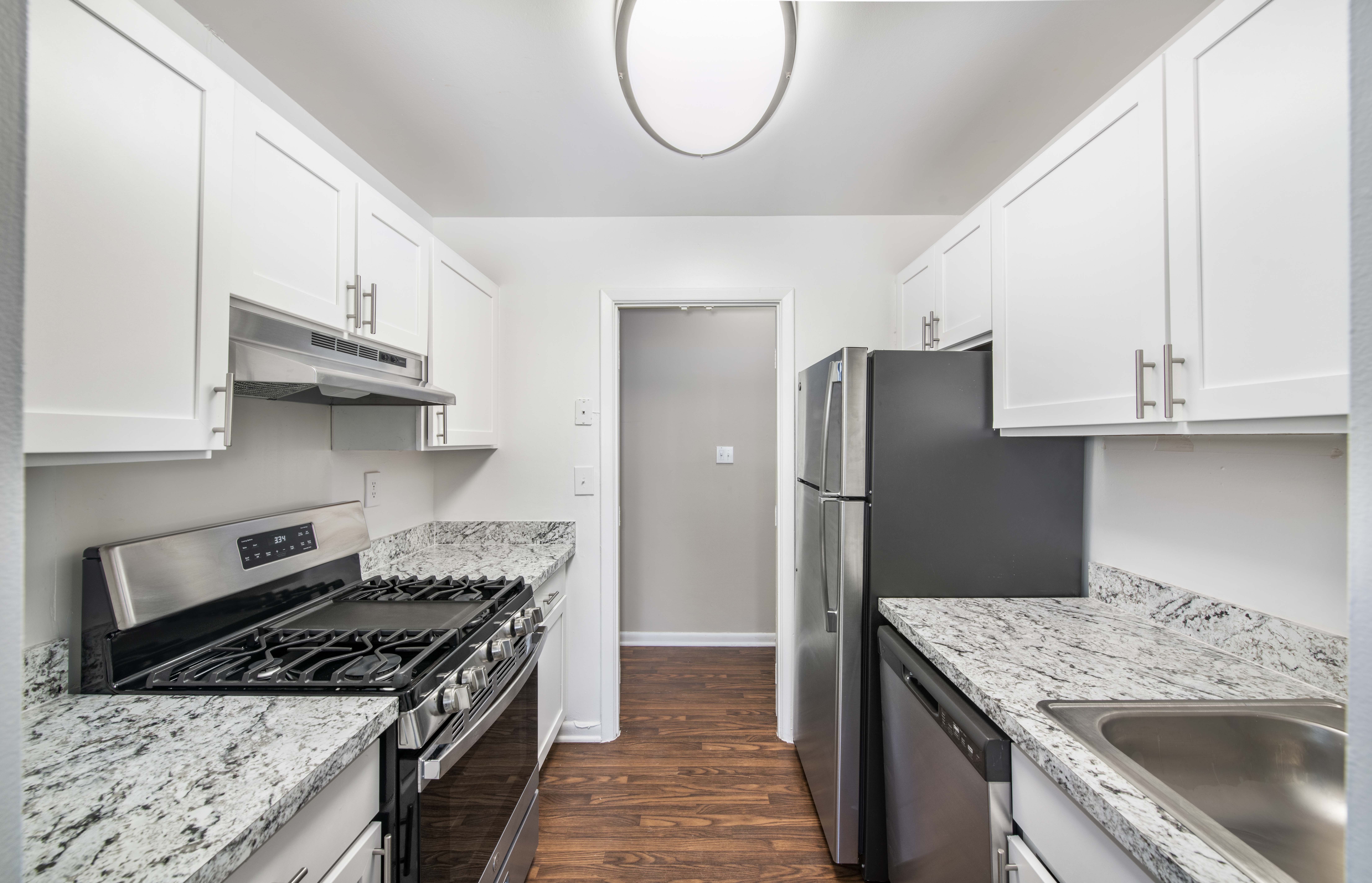 A kitchen with a black fridge and stove top oven.