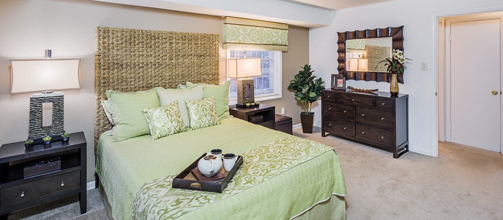 a bedroom with a bed and a dresser and a mirror