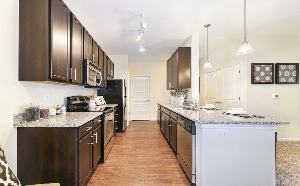 A kitchen with dark brown cabinets and a white counter.