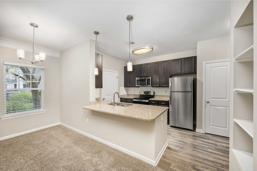 A kitchen with a stove top oven and a refrigerator.