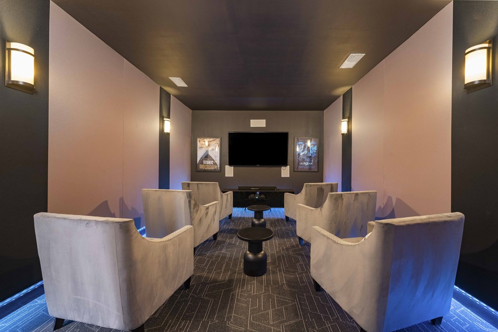 A room with a row of chairs and a table in the middle.