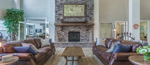 a living room with leather furniture and a brick fireplace