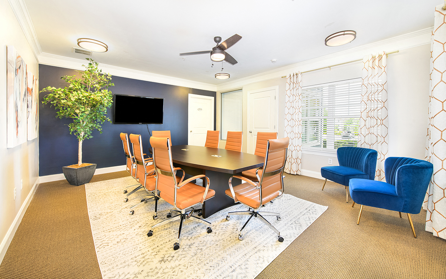 a conference room with a table and chairs and a tv