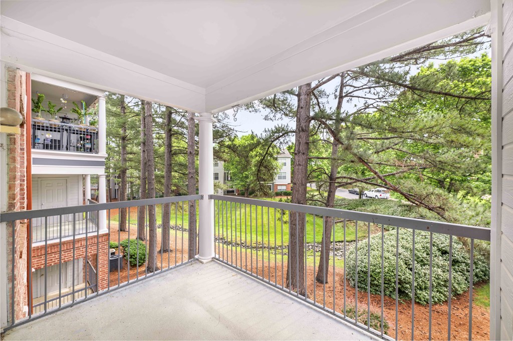 a balcony with a view of a yard and trees