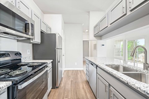 A kitchen with a stove top oven and a refrigerator.