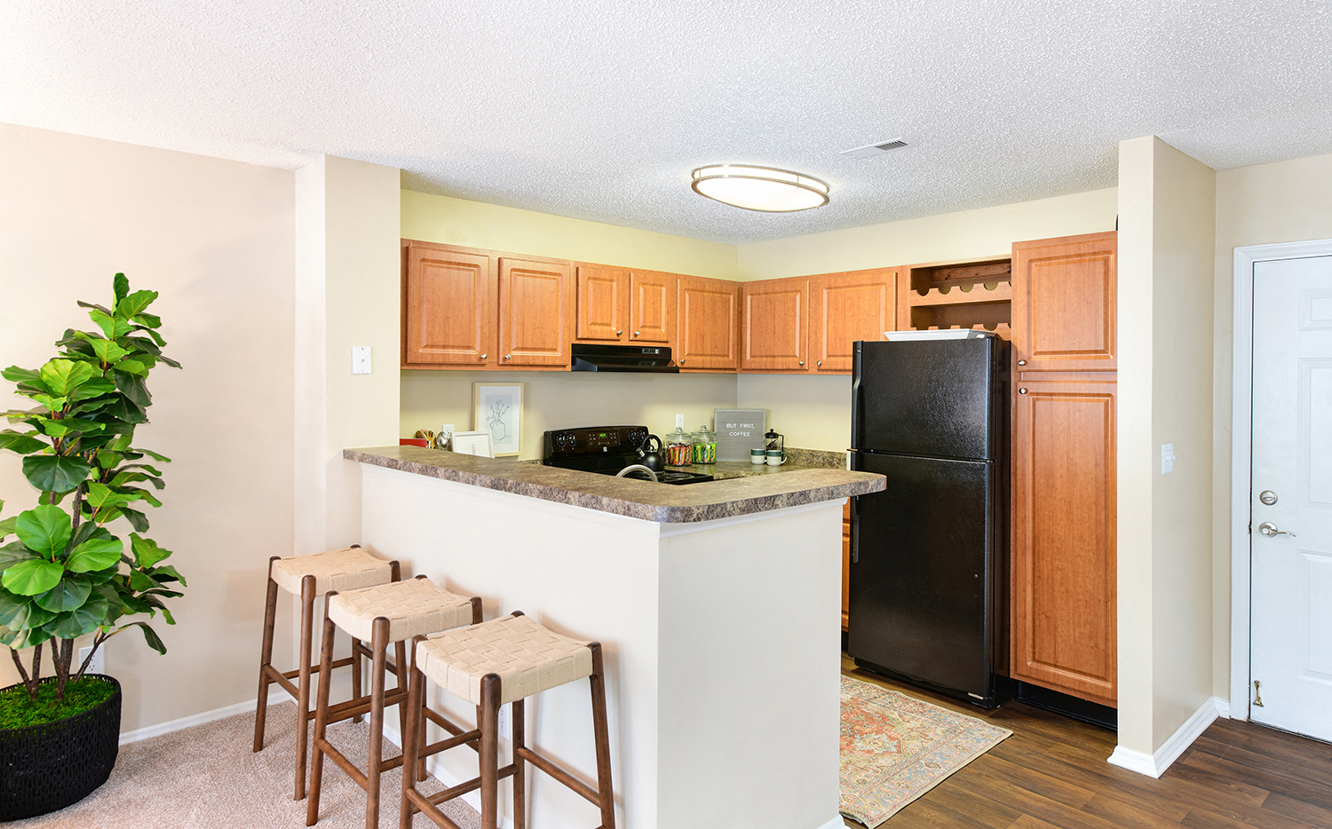 a kitchen with a counter with three bar stools